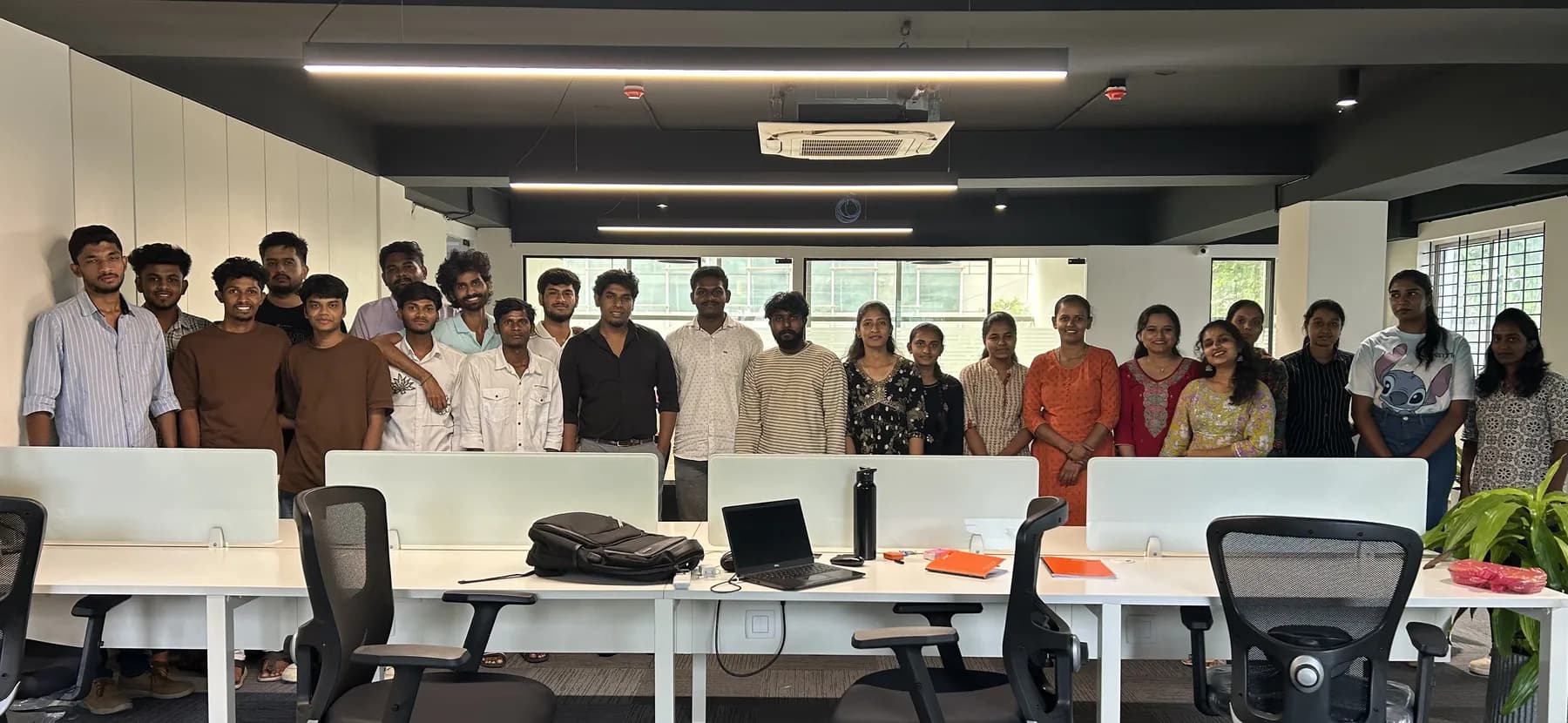 The whole Brightnodes team standing together on the open floor of the Bengaluru office